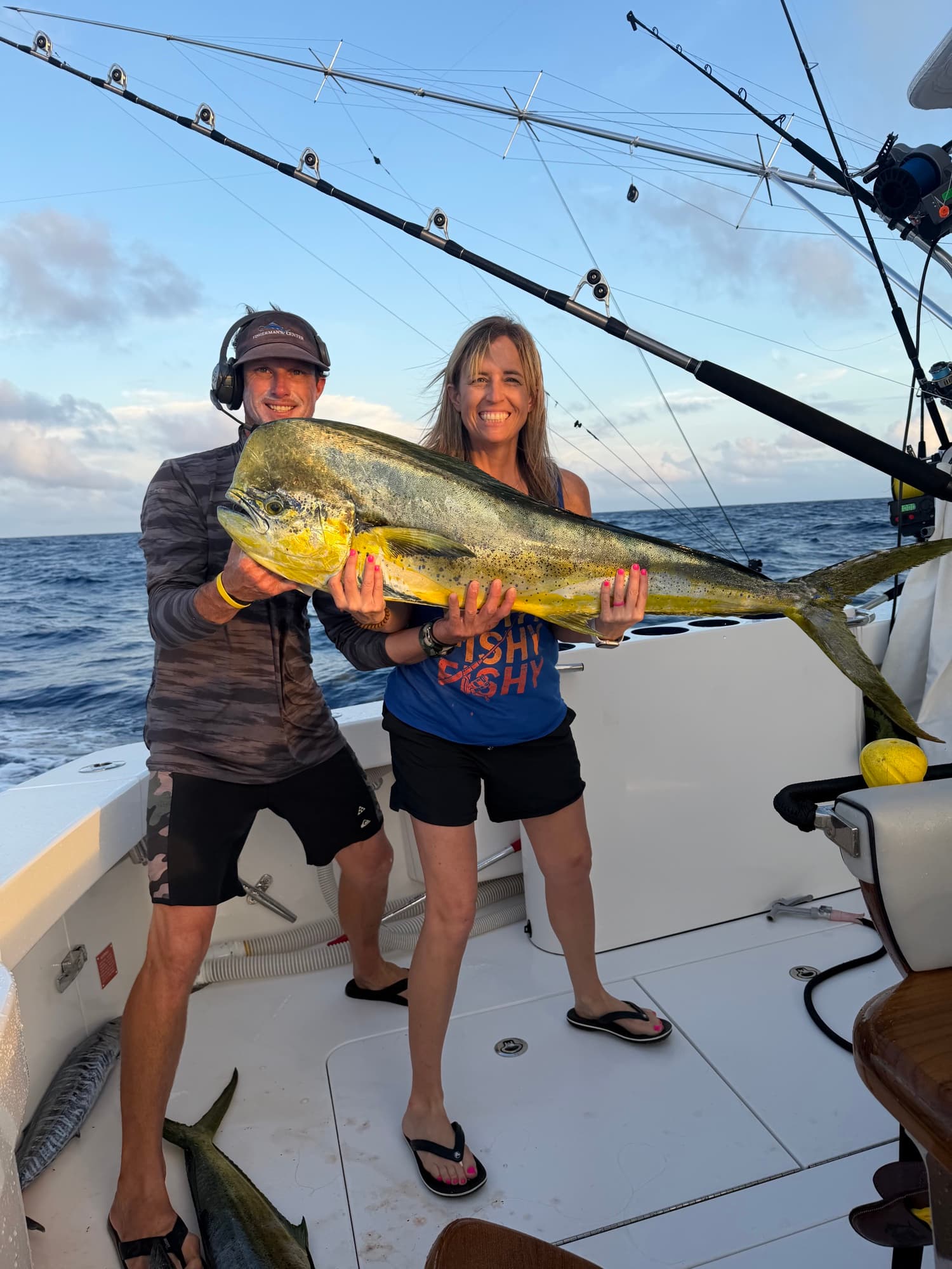 Couple holding a bull dorado at sunset on the cockpit
